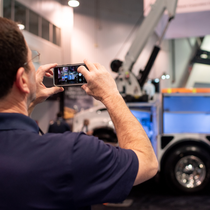 Guy taking picture of truck at CONEXPO-CON/AGG